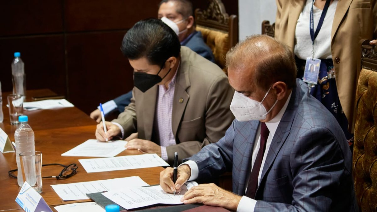 Momentos en que el gobernador del Guayas, Vicente Taiano, firma un convenio con la academia.