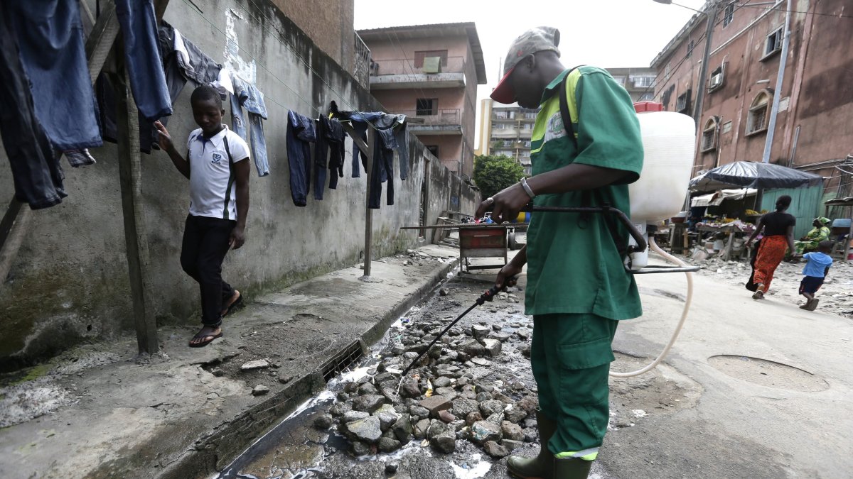 Un empleado del Instituto de Higiene Pública fumiga con insecticida una calle para exterminar mosquitos y prevenir la malaria en Costa de Marfil.