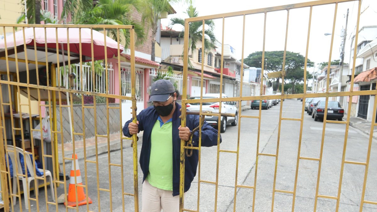 Personas, sin ningún implemento de defensa, son las encargadas de cuidar las puertas de fierro que cierran las cuadras de la ciudadela Los Almendros.