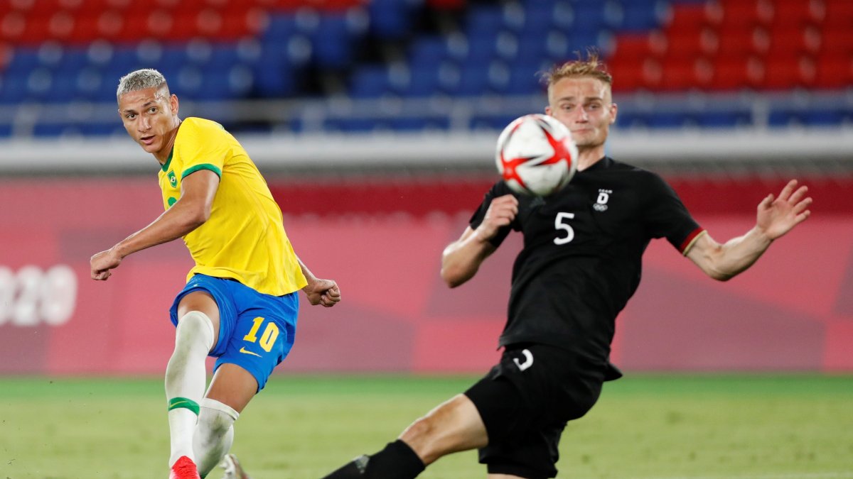 Richarlison, autor de tres goles para Brasil, ejecuta un disparo ante la marca de un alemán.