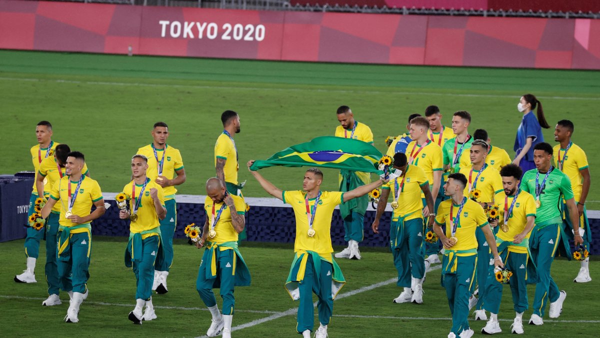 Los jugadores de Brasil se pasean por la cancha con la medalla de oro conseguida en la final del fútbol masculino.