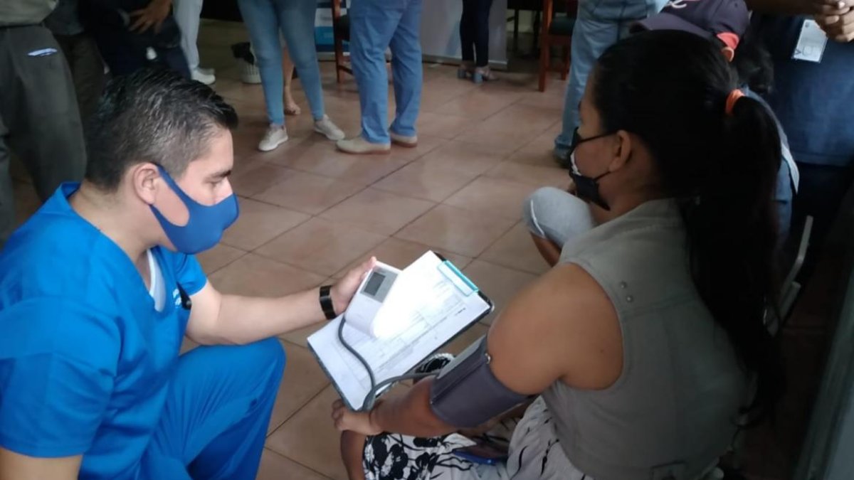 La venezolana Jéssica Castillo es valorada por un médico antes de aplicarle la vacuna.