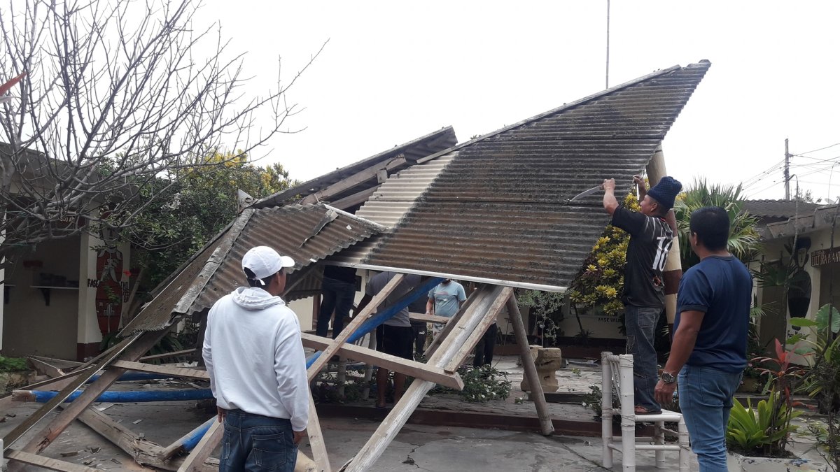 Un grupo de habitantes de Valdivia recogen los escombros del techo que se cayó en el museo del lugar.