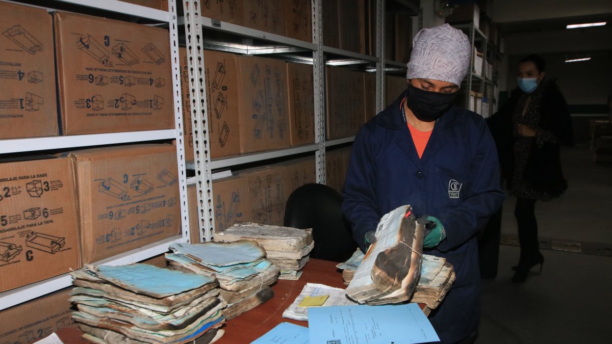 Vicente Celi limpia la ceniza de uno de los archivos quemados.