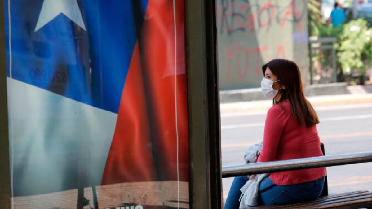 Una chilena espera por transporte en una calle de Santiago. El país del Cono Sur recupera poco a poco la normalidad.