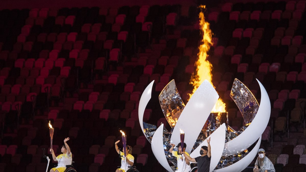 Three athletes light the fire during the opening ceremony during the opening ceremony of the 2020 Tokyo Summer Paralympics Games.