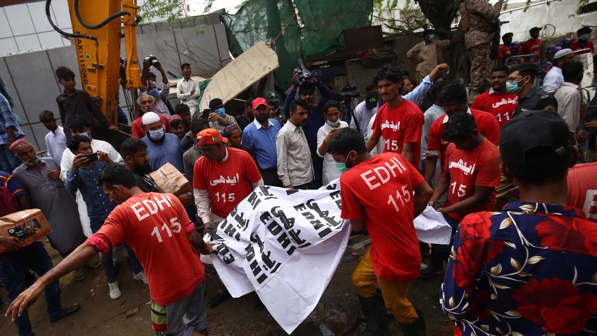 Rescatistas cuando sacan uno de los cuerpos calcinados.  SHAHZAIB AKBER