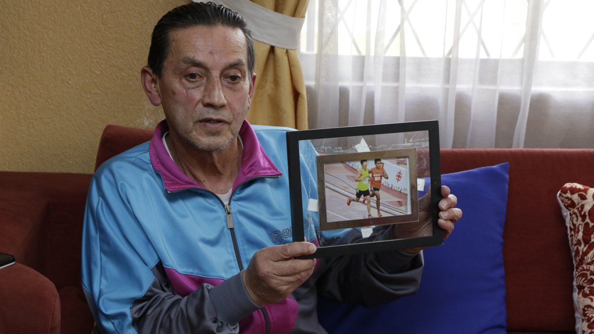 Juan Rosero muestra orgulloso una foto de su hijo Sebastián en competencia junto a Darwin Castro, tras sumar su segundo diploma paralímpico.