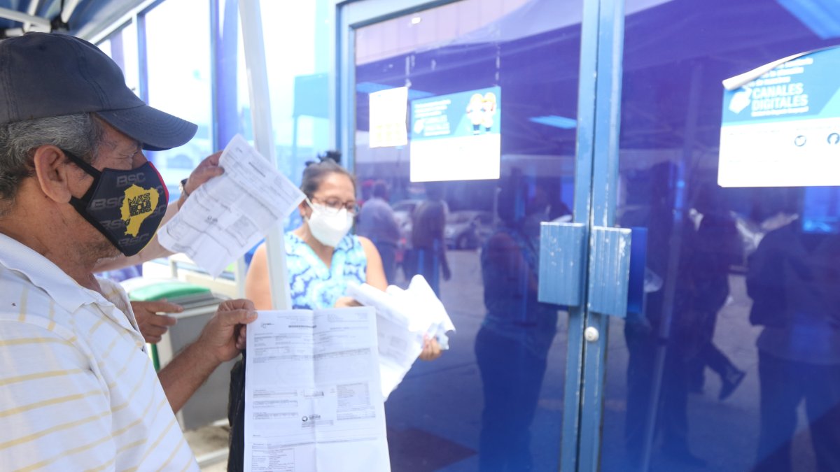 Inconformidad. En los exteriores de las dependencias de CNEL usuarios esperan que atiendan sus reclamos.