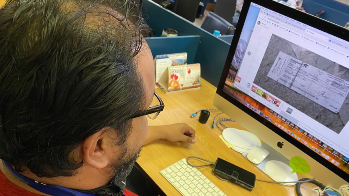 Referencia. Un vendedor analiza el comprobante de un cheque tras la venta de un producto en Internet.