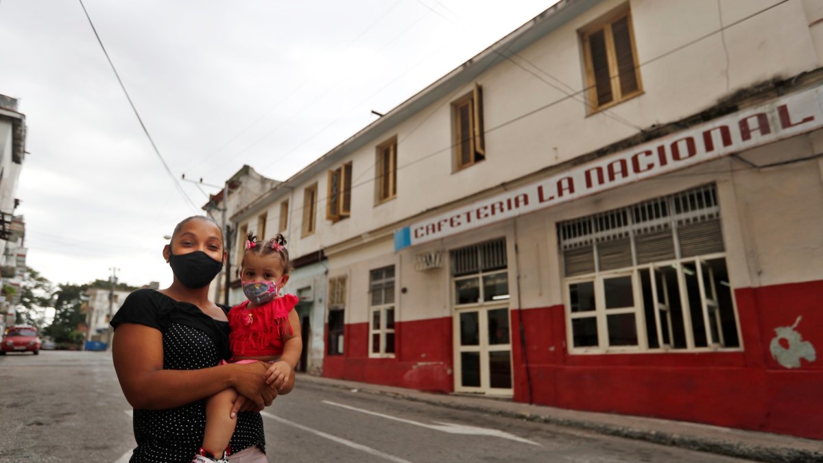 Una madre con su hija en brazos posa para Efe en una calle hoy, en La Habana (Cuba). EFE/ Yander Zamora