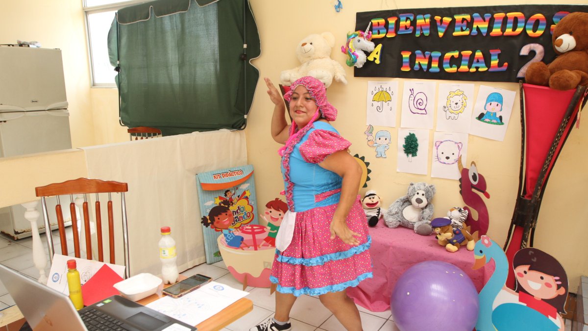Vestida de muñeca, la parvularia Liliana Bohórquez baila frente la pantalla, mientras al otro lado sus alumnos aprenden con ella los colores y los números.