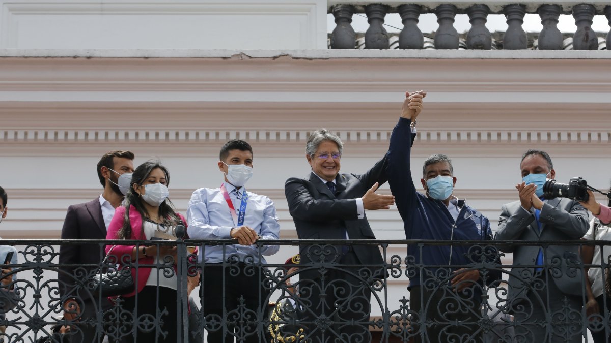 El presidente Lasso, con Carapaz a su derecha, levantó la mano también del padre del ciclista, quien lo acompañó al balcón del palacio de Carondelet.