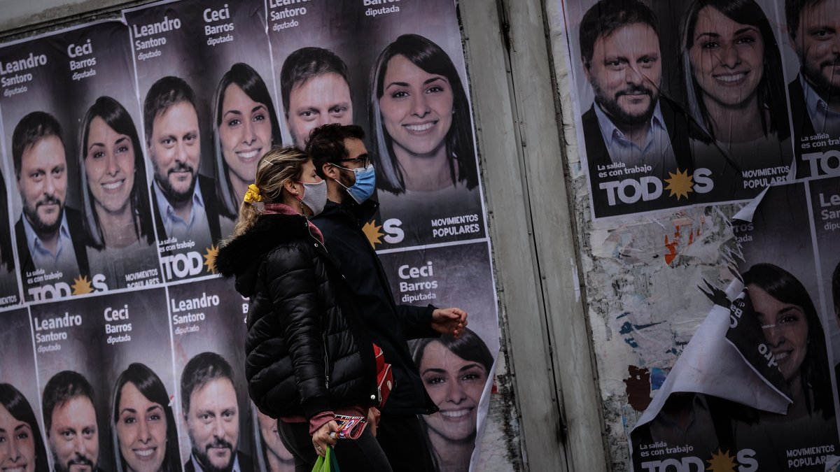 Una pareja camina frente a un cartel con la cara de Leandro Santoro, candidato a Diputado Nacional por el Frente de Todos, el 9 de septiembre de 2021, en la Ciudad de Buenos Aires (Argentina). 