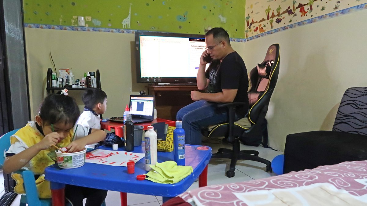 Washington Sánchez ayuda a sus dos hijos, que estudian en la Unidad Educativa Mariscal Sucre, en las clases virtuales en casa, mientras él labora en la modalidad de teletrabajo.