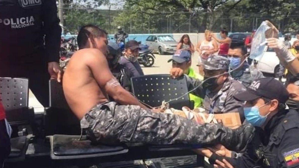 Un agente de la Policía herido es retirado del sector en ambulancia.