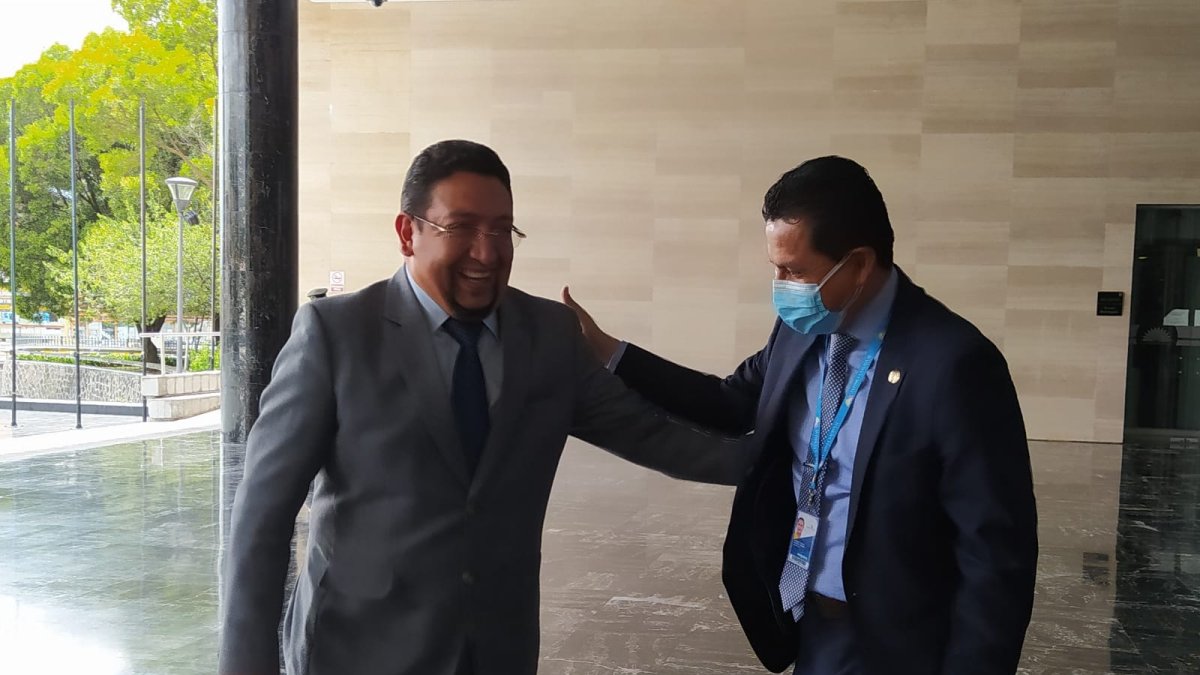 Los asambleístas Virgilio Saquicela y Darwin Pereira, que tienen posturas distintas, saludan en el ingreso a la Asamblea Nacional.