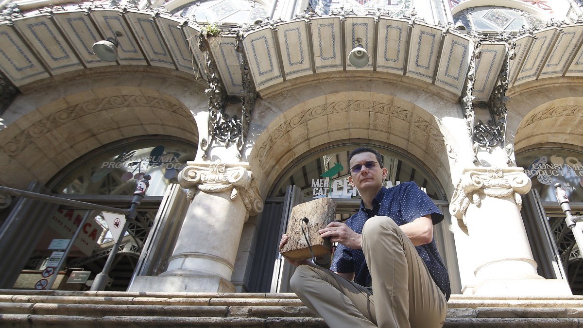 Miguel Ángel Abián muestra uno de los sensores a las puertas del Mercado Central de Valencia.