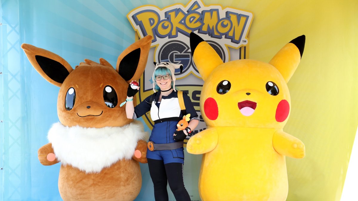 Una chica posa con Pikachu y Eevee en foto de archivo.