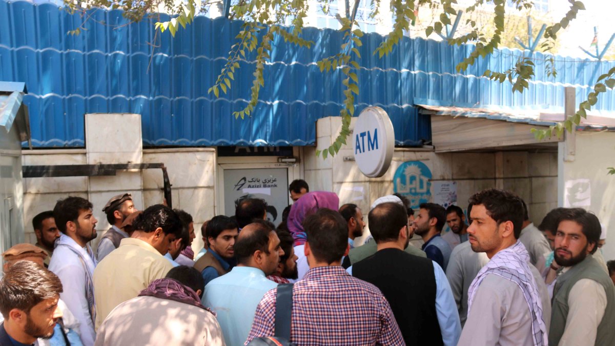 Afganos aguardan afuera de un banco cerrado en Kabul, Afganistán, para intentar retirar dinero.