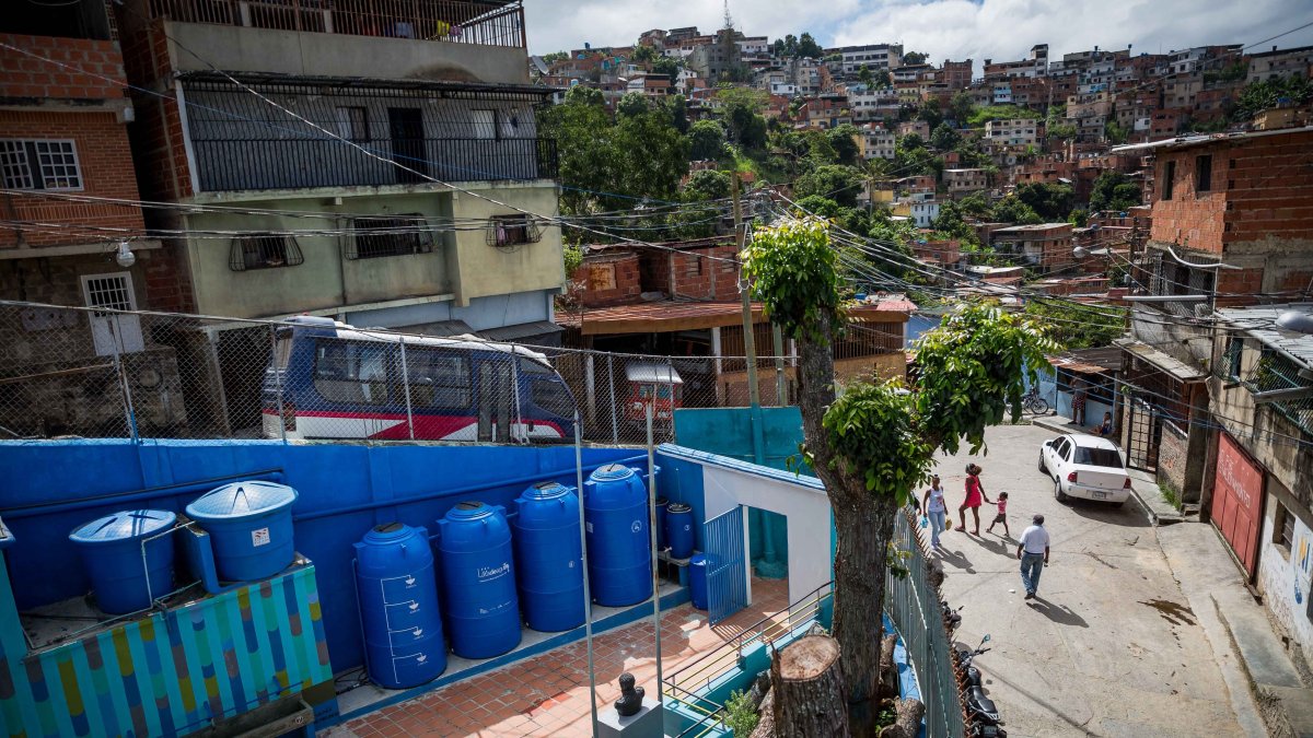 En la fotografía se puede apreciar tanques y filtros de agua de lluvia en la entrada de una escuela.