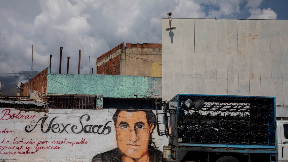 Caracas. Un pequeño camión pasa junto a un grafiti con la imagen del rostro de Alex Saab en Venezuela, en una imagen de archivo.