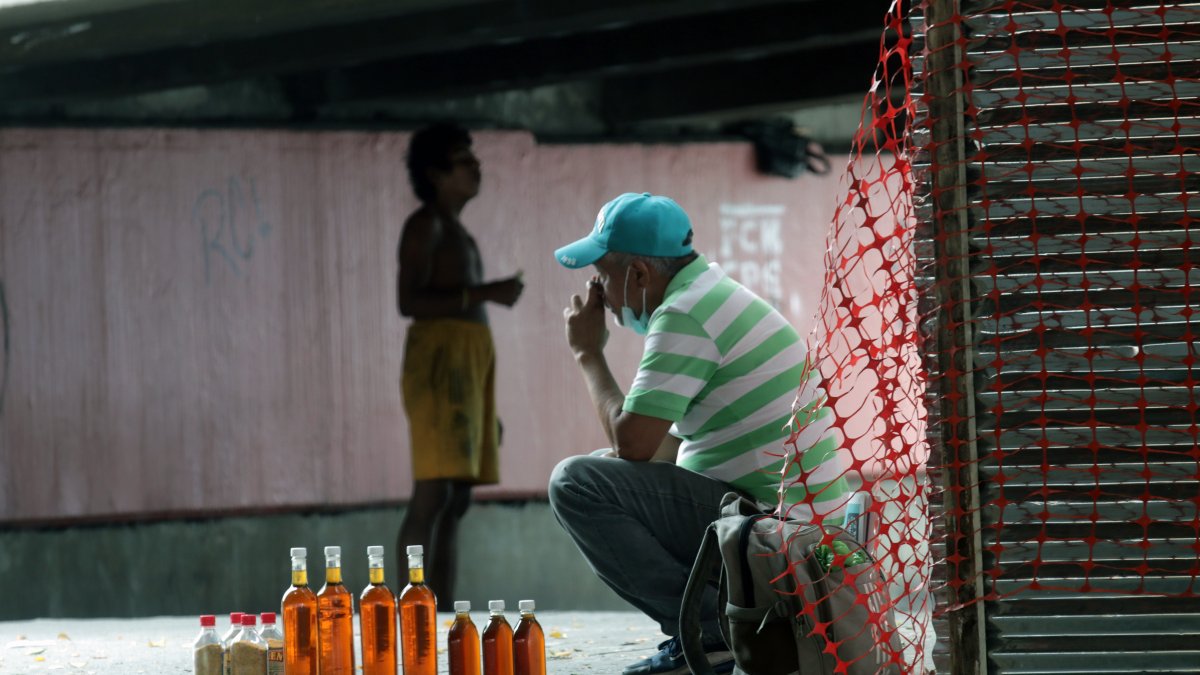 Mientras un hombre vende miel a orillas del paso peatonal de la avenida 25 de Julio, en el sur de la ciudad, otro vive en la indigencia. Apenas un metro separa sus realidades. Ambos, a su manera, buscan obtener unos dólares para sobrevivir.