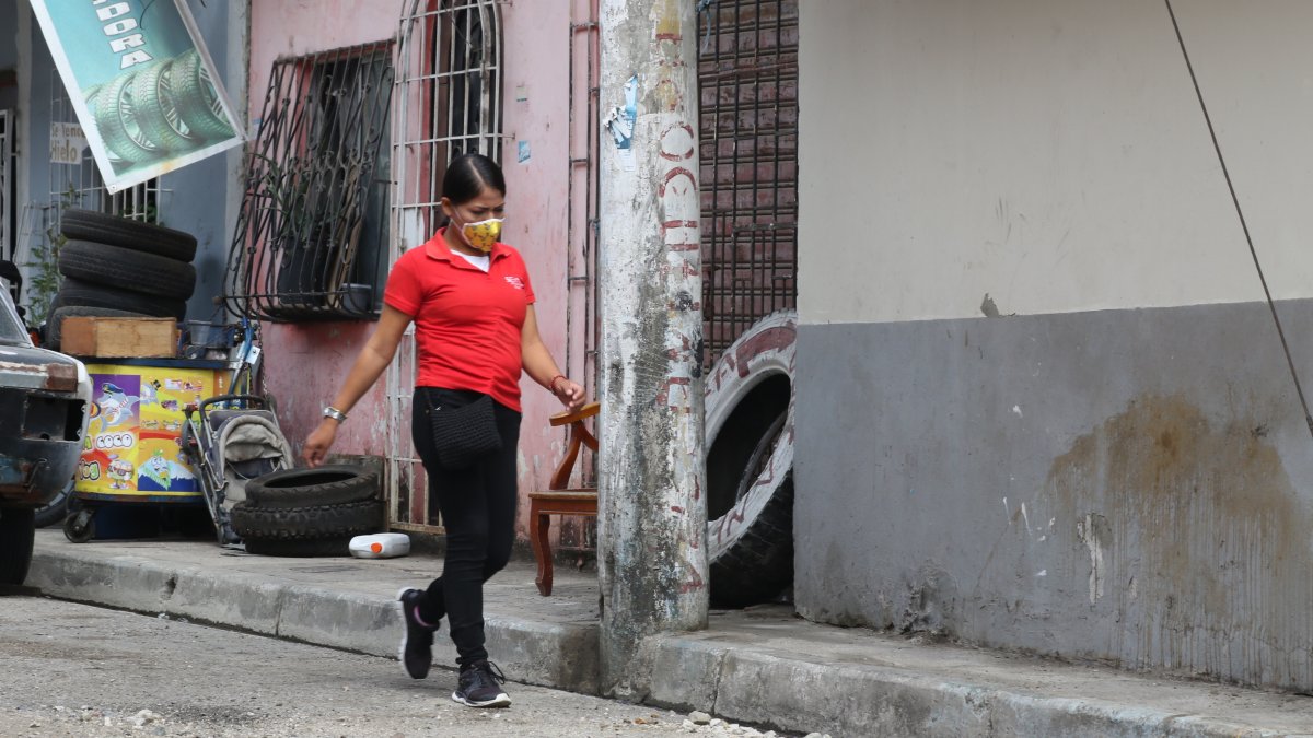 Obstáculo. Una persona camina en la vía por donde van los carros porque el poste ocupa la estrecha acera de la calle Mercedes Arzube y no hay espacio.