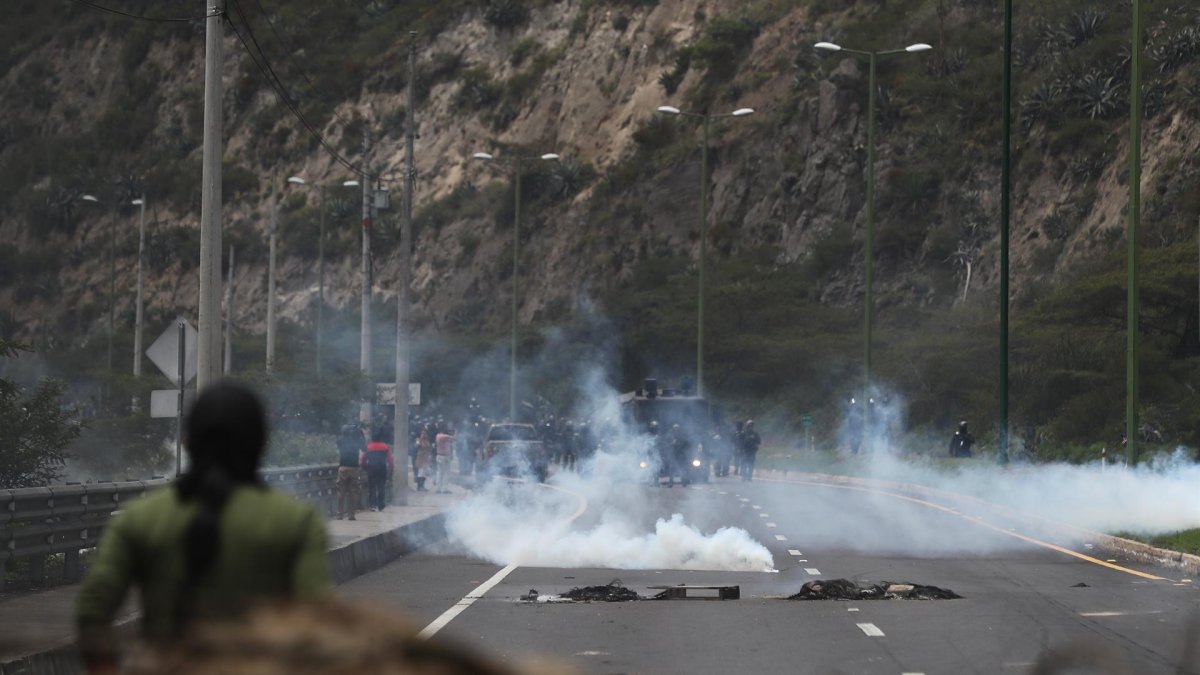 Policías antimotines se presentan en una vía bloqueada por manifestantes durante las movilizaciones contra las pretendidas reformas del Gobierno. Hoy, en el acceso norte de Quito (Ecuador).