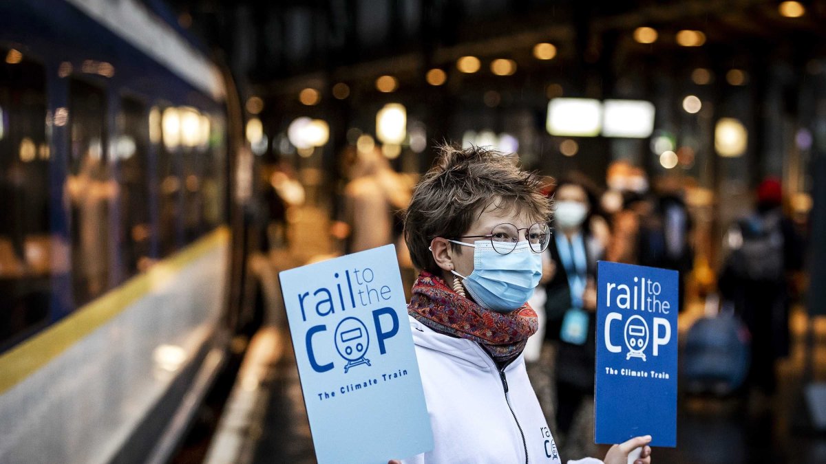 Pasajeros en Ámsterdam toman el llamado 'tren climático' con destino a Londres para luego tomar otro transporte hasta Glasgow, sede del evento.