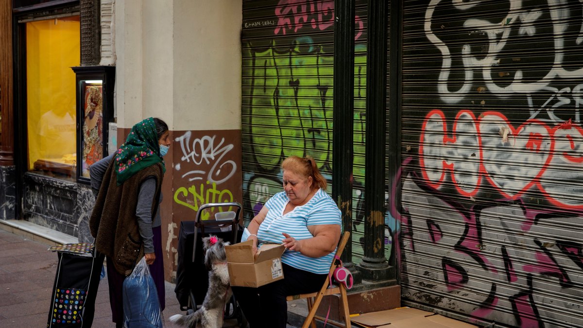 Dos mujeres que ejercen la mendicidad conversan en una céntrica calle de Sevilla EFE/Julio Muñoz