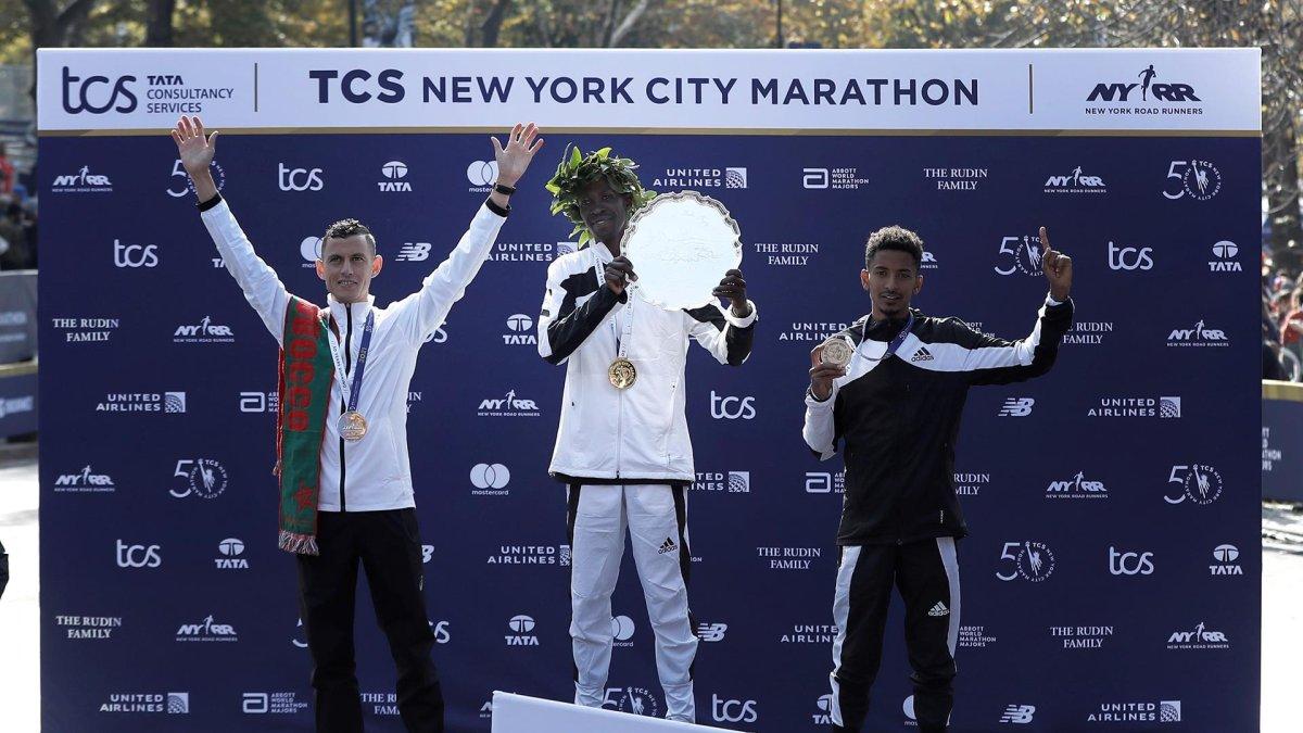 El ganador del maratón de Nueva York, el keniano Albert Korir (c), el subcampeón, Mohamed El Aaraby (i), y el tercer lugar, Eyob Faniel, festejan durante la premiación de la carrera.