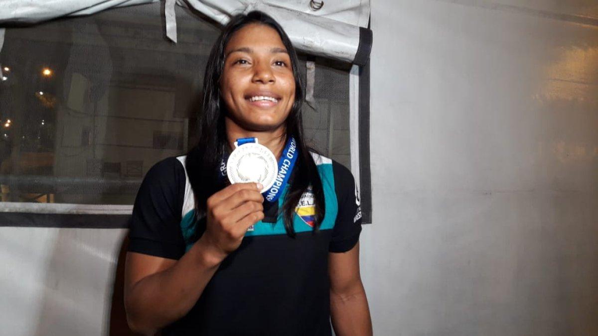 Lucía Yépez muestra su medalla al llegar a suelo nacional.