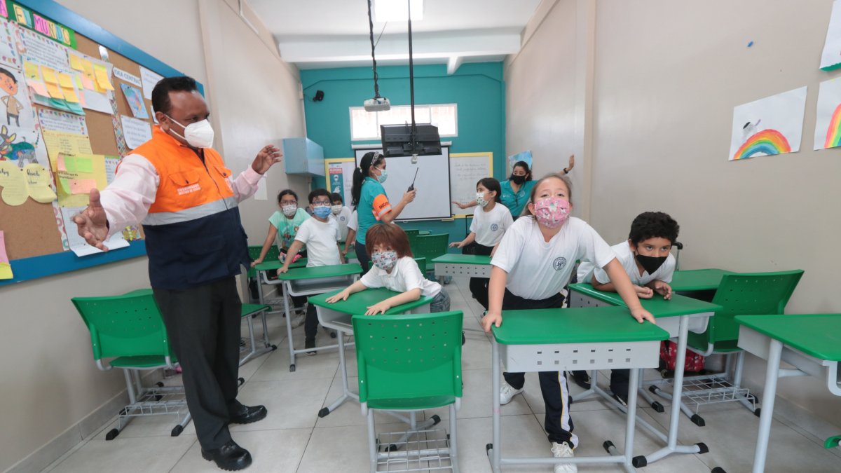 Los estudiantes del Liceo Panamericano arrastran sus pupitres hasta la puerta para formar una barricada, durante un simulacro de atentado en el plantel.