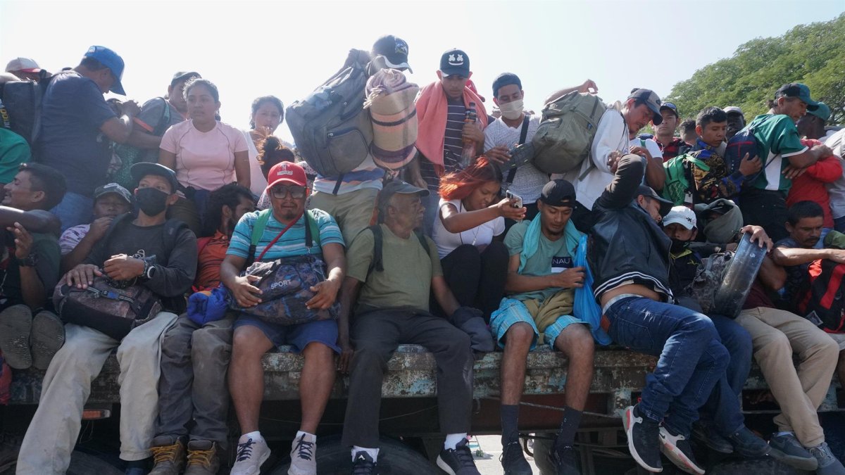 Migrantes centroamericanos abordan camiones, para continuar con su caravana hacia EEUU, este viernes en la comunidad de Santiago Niltepec, en el estado de Oaxaca (México).