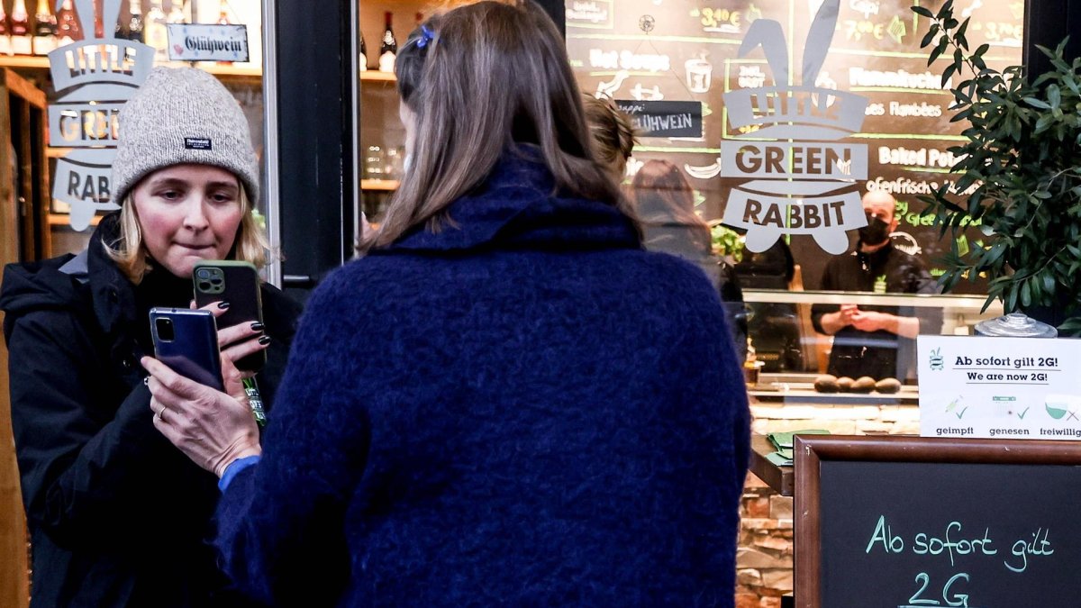 Unas clientas muestran su pasaporte de vacunación para acceder a un restaurante en Berlín.