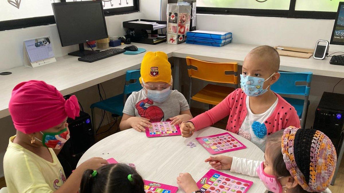 En la sala de juegos de Solca, los niños participan en diferentes actividades. El Comité de Damas alista el bingo para este 20 de noviembre. 