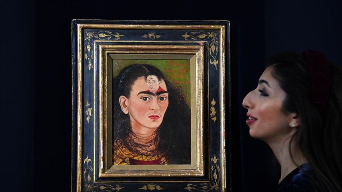 El personal de una casa de subastas de Sotheby's con el último autorretrato del 'busto' de la artista mexicana Frida Kahlo, titulado 'Diego y yo' (Diego y yo), en Sotheby's en Londres, Gran Bretaña, el 21 de octubre de 2021.