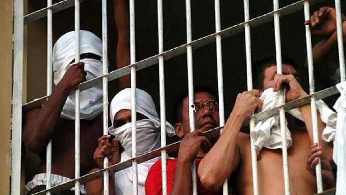 Un grupo de personas privadas de la libertad, tras las rejas.