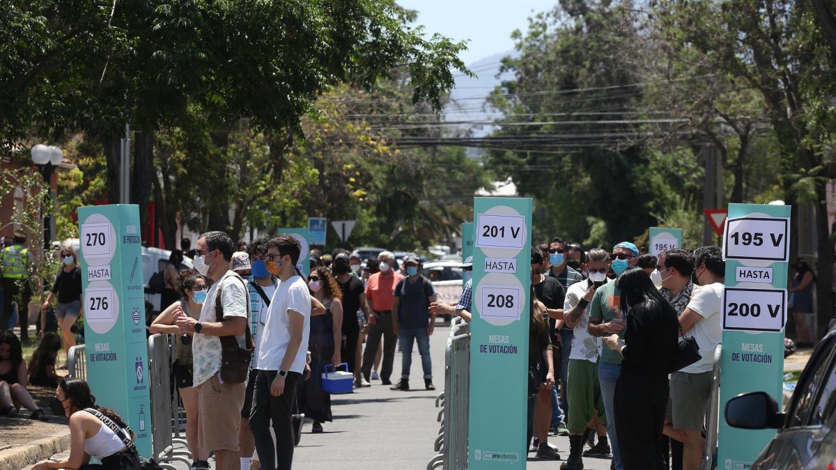 Ciudadanos hacen fila para ingresar a un colegio electoral hoy, en Santiago (Chile).