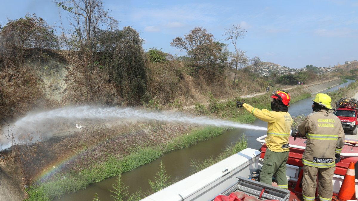 Una llanta envuelta en llamas es apagada por los bomberos en la cooperativa Janeth Toral.