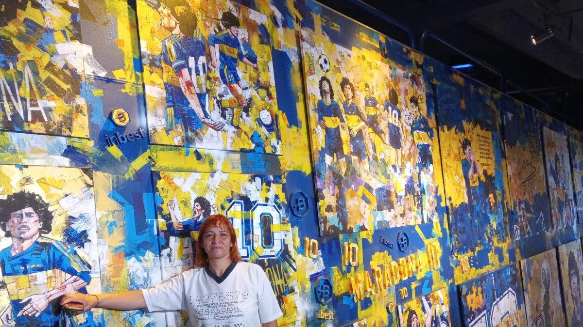 Mariana Vega, integrante de la Iglesia Maradoniana, junto a un mural del astro que pintó Boca Juniors.