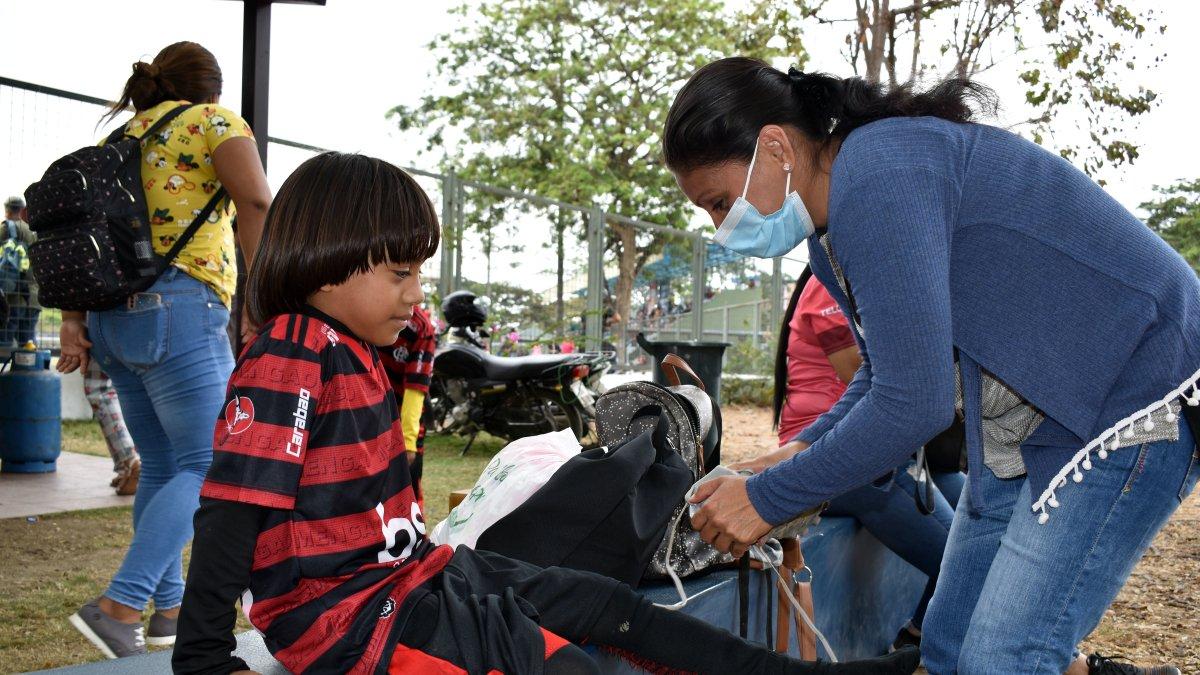 Israel Llerena Rendón, figura de la escuela de fútbol Los Tigrillos y admirador de Lionel Messi, es ayudado con la equipación por su madre Edilma, en la Copa Extra.