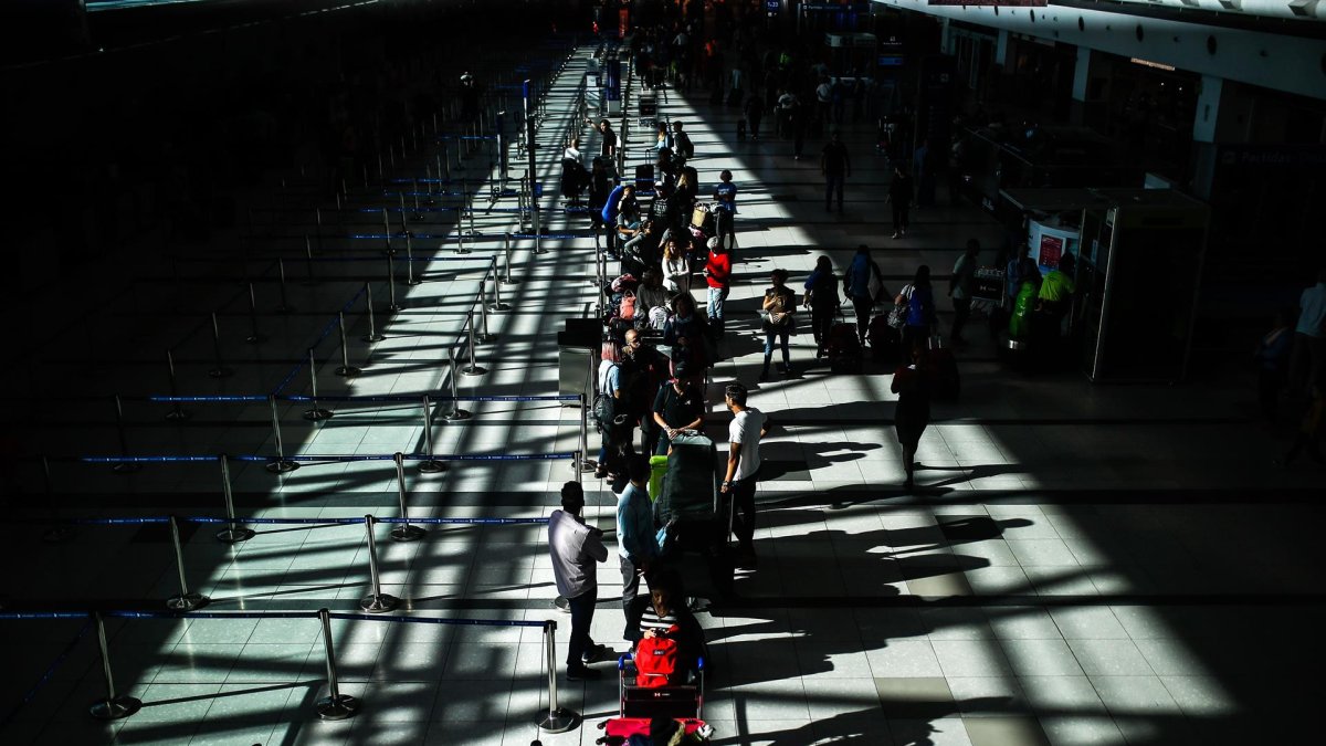 Pasajeros usan tapabocas para protegerse del coronavirus mientras transitan por el Aeropuerto Internacional de Ezeiza, en Buenos Aires (Argentina), en una fotografía de archivo.