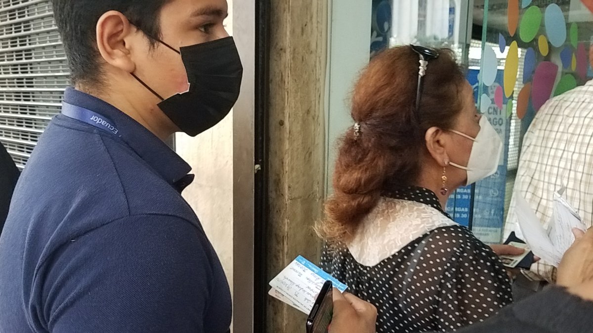 Con su carnet de vacunación a la mano, un ciudadano espera su turno para ingresar a una entidad pública para realizar un trámite.