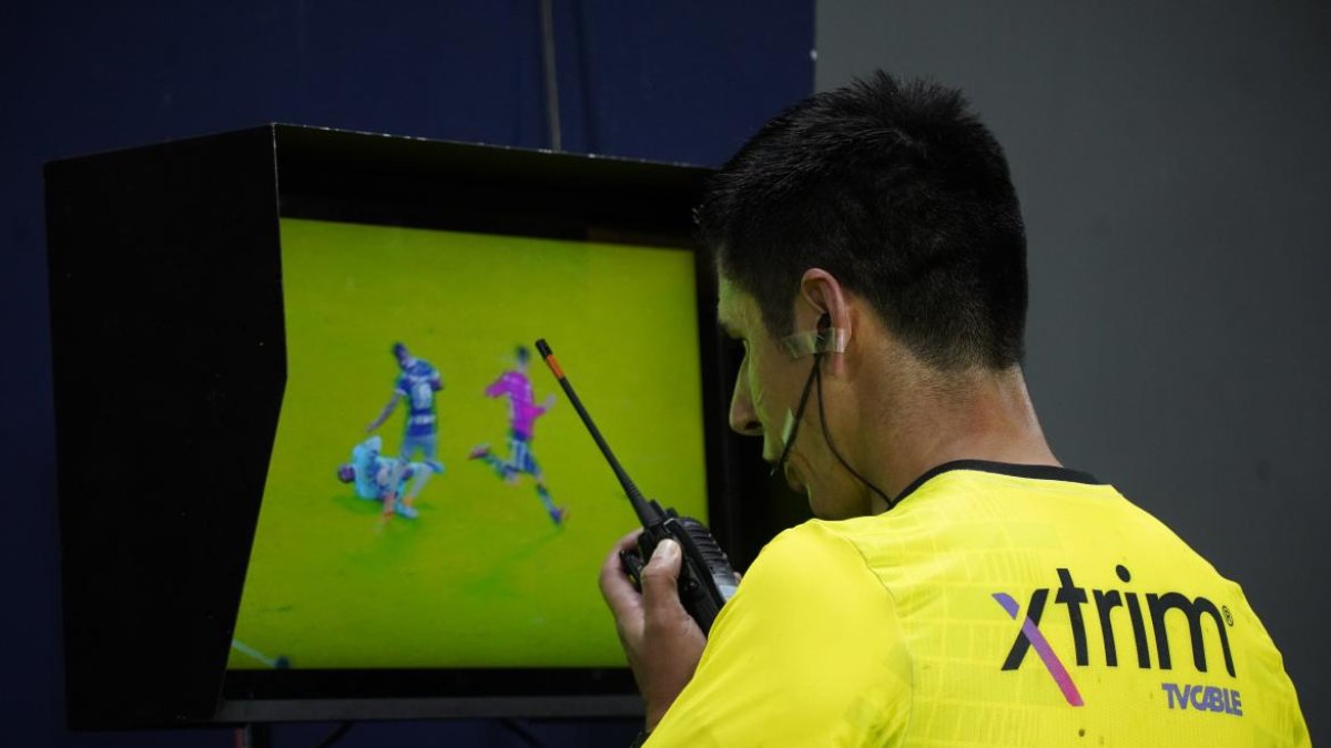 El juez Luis Quiroz se comunica con los árbitros del VAR por una acción dudosa.