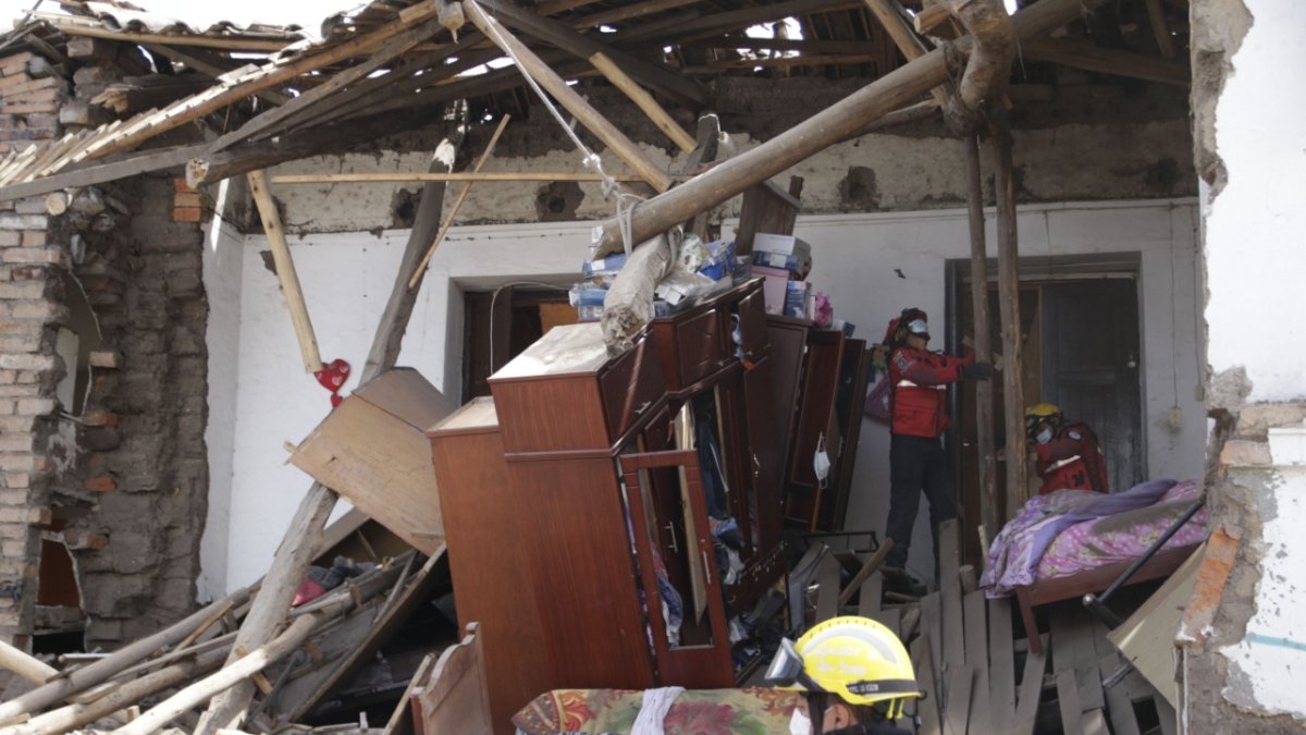 Actuación. Miembros del Cuerpo de Bomberos inspeccionan la casa afectada por efecto de la lluvia.