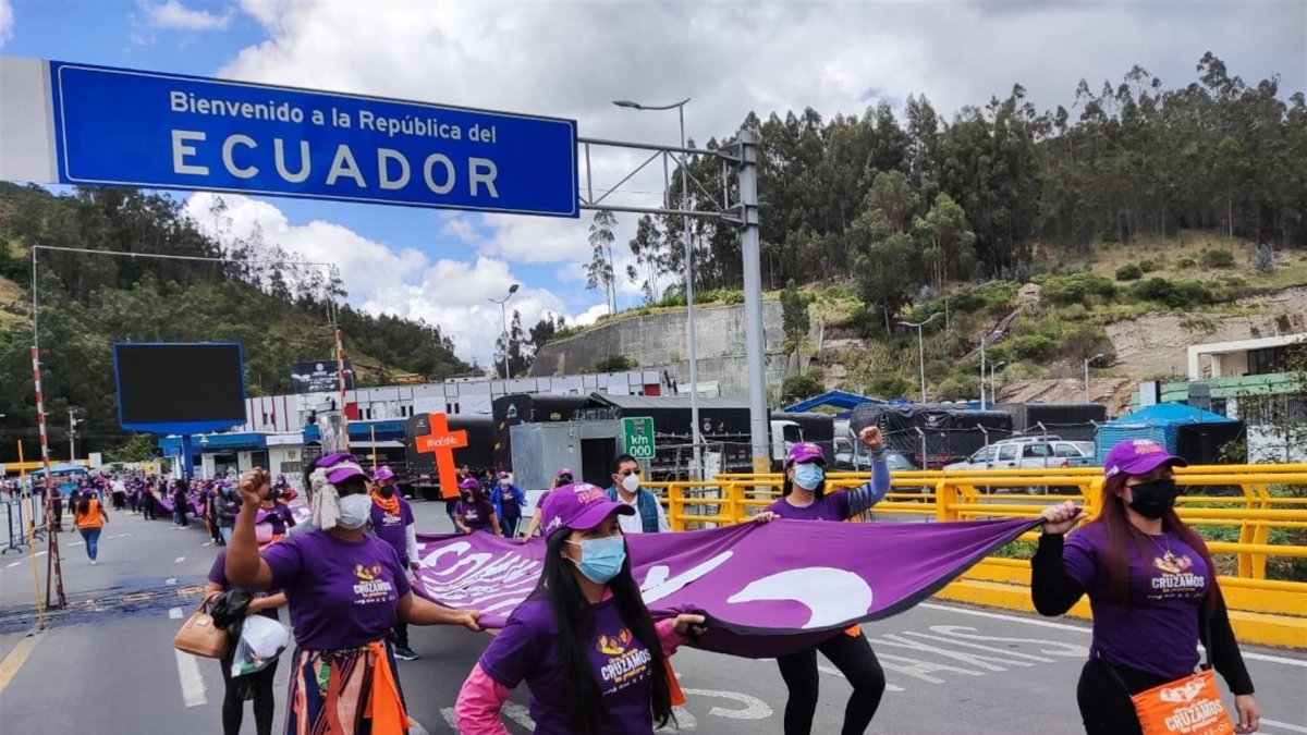 Fotografía cedida por CARE Ecuador de mujeres marchando hoy en el Puente Internacional de Rumichacha, frontera de Ecuador con Colombia.