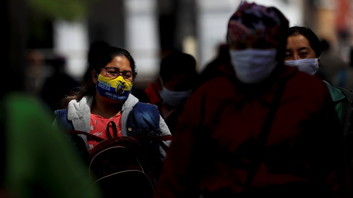 Referencial. Personas con mascarilla caminan por una calle en la ciudad de Quito.