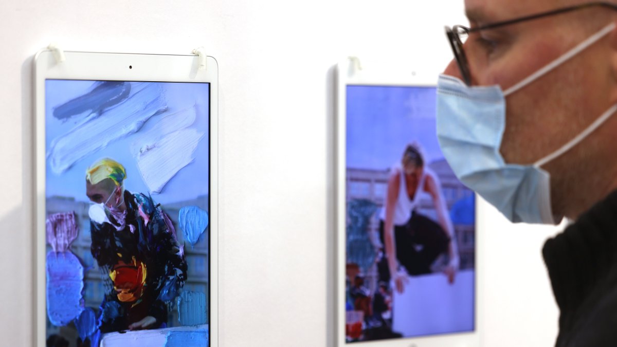 Un hombre observa un NFT del artista Erik Schmidt en la pantalla de un iPad en la feria Art Cologne.